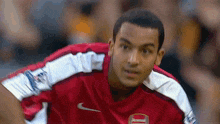 a soccer player wearing a red jersey with the number 10 on it is looking at the camera .