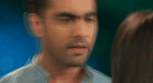 a man and a woman are looking at each other and the man is making a funny face .