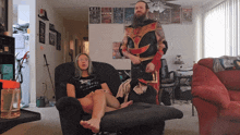 a man in a costume is standing next to a woman in a black shirt that says ' eternity ' on it
