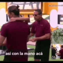 a man in a maroon shirt is hugging another man .