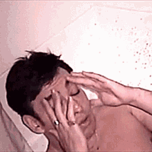 a man with a ring on his finger is laying in a bathtub