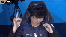 a man wearing headphones and a shirt that says replay
