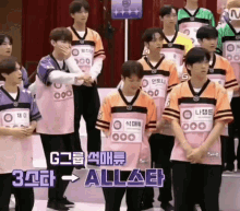 a group of young men wearing pink and orange jerseys are standing next to each other .