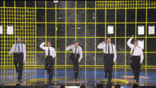 a group of men in suits and ties perform on a stage