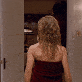 a woman is wrapped in a red towel and standing in a doorway