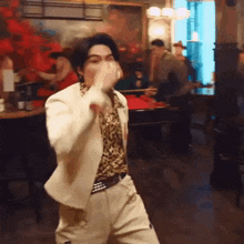 a man in a white suit is dancing in a bar .