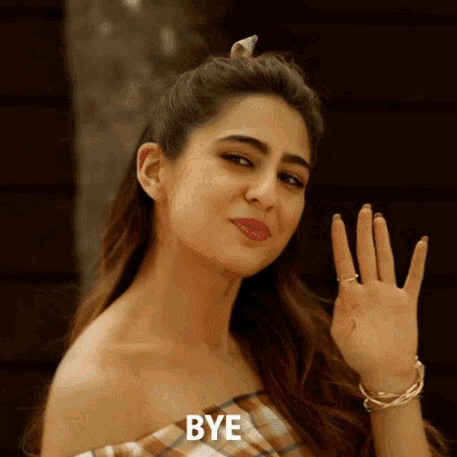 a woman waving her hand with the word bye written below her