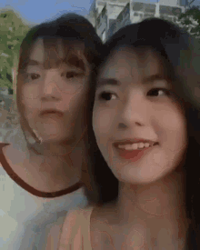 two girls are posing for a picture and one of them is smiling