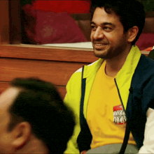 a man wearing a yellow shirt with a name tag that says " who 's who "