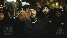 a group of men are standing next to each other and one of them is wearing a nike jacket .