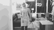 a man in an apron is standing in front of a couch in a living room