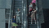 a group of girls are standing on an escalator with one wearing a sweater that says ' a ' on it