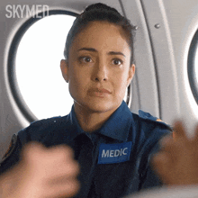 a woman in a skymed uniform has a blue patch on her chest that says medic
