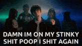 a man is standing in front of a group of people and says damn im on my stinky shit poop i shit again