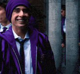 a man wearing a purple jacket and a purple hat