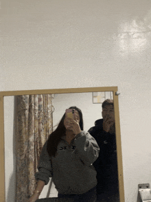 a man and a woman are taking a picture of themselves in the mirror