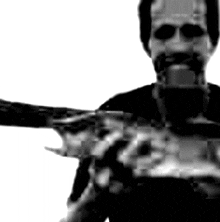 a man with a beard is holding a gun in his hand .
