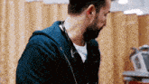 a man with a beard is wearing a stethoscope around his neck in a hospital .