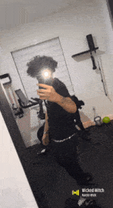 a person taking a picture of themselves in a mirror with the words wicked witch on the bottom