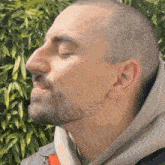 a man with a beard is wearing a grey hoodie