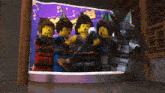 a group of lego ninjago characters wearing party hats and holding a microphone