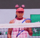 a tennis player holds a tennis racquet in front of a scoreboard with the number 7 on it