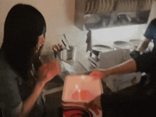 a woman holds a box with a candle in it