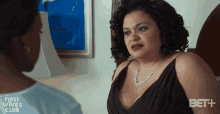 a woman in a black dress is talking to another woman in a first wives club advertisement