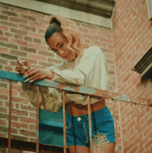 a woman smoking a cigarette while leaning on a railing