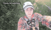a man wearing a petzl helmet and a plaid shirt takes a selfie