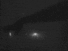 a black and white photo of a person 's face in the dark .