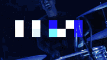 a man playing drums with the word love written in pixel art