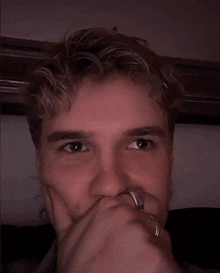 a man with a ring on his finger is making a funny face