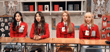 a group of young women are sitting at desks in a classroom .