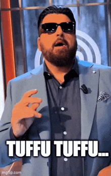 a man wearing sunglasses and a suit says tuffu tuffu ...