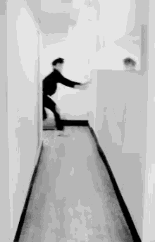 a man is standing in a hallway leaning against a wall