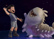 a boy is standing next to a cartoon monster with a large mouth