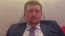 a man in a suit and tie is sitting on a plane .