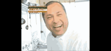 a man in a white shirt is smiling in front of a sign that says ' chicken curry '