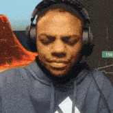 a man wearing headphones and a blue hoodie with an adidas logo