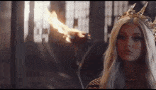 a woman is wearing a crown and holding a torch .