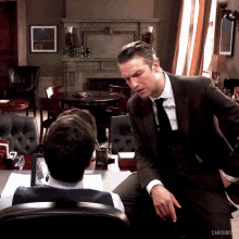 a man in a suit and tie is standing next to another man