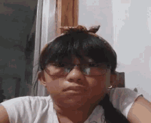 a young girl wearing glasses and a headband is making a face .