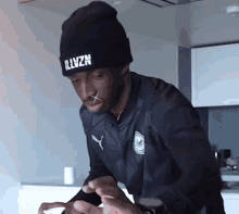a man wearing a black beanie that says illvzn on it