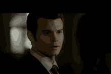 a man in a suit and tie is looking at a woman