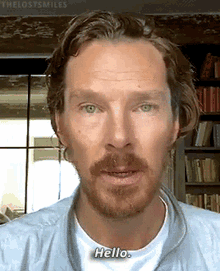a man with a beard and green eyes says hello in a video