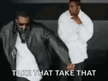 two men are dancing together and the words `` take that take that '' are on the bottom of the image .