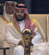 a man in a white robe is holding a trophy with the number 1 on it