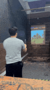 a man throws an axe at a screen that shows a castle on it