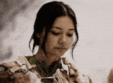 a woman wearing a green shirt and a fur coat looks down